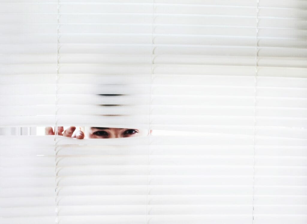 insurance adjuster peeking through window blinds