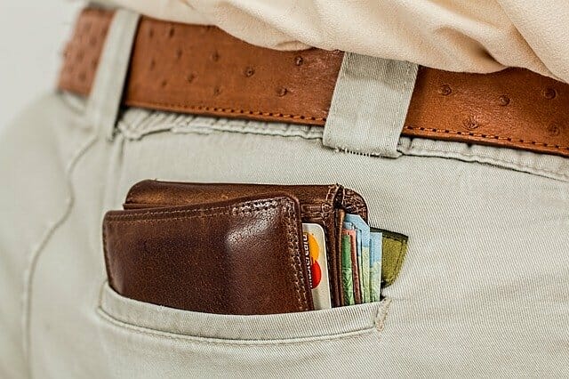 man's back pocket with wallet and money in it